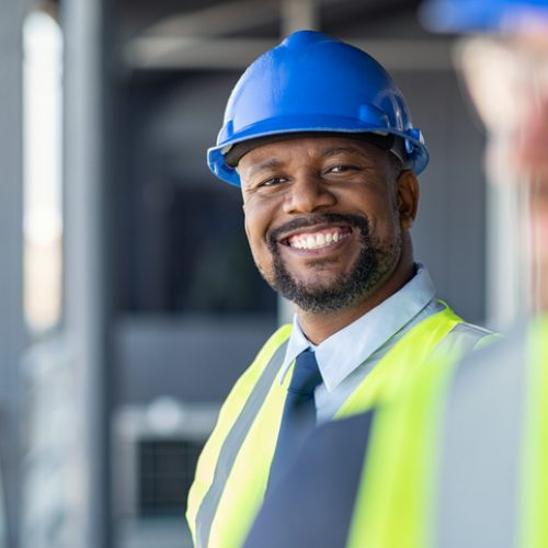 Employee on a construction site in a hard hat and neon vest