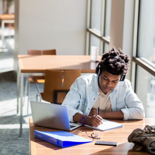 A student writing at a table