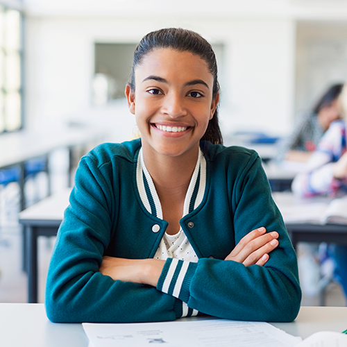 Student sitting at desk smiling
